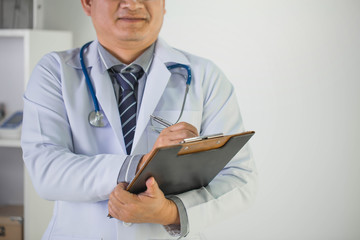 Doctor with a stethoscope in the hands behind the white background.