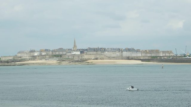 Boat floats in the Atlantic Ocean along the fortress of Saint-Malo, France