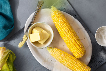 Raw sweet corn with butter and salt top view