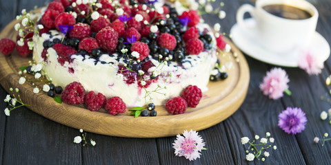 Cheese cake with currant and raspberries on a black background