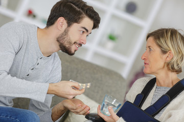 Obraz premium young man giving pills to an ill woman