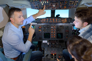 Man showing cockpit controls to young people © auremar