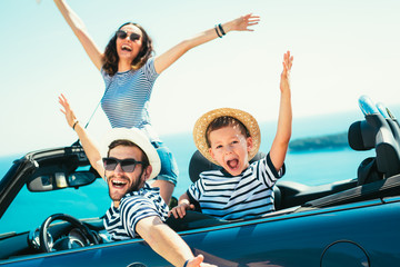 Happy family travel by car to the sea. People having fun in cabriolet. Summer vacation concept
