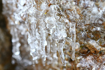 Obraz na płótnie Canvas The thawing icicles with the falling water drop in the mountains