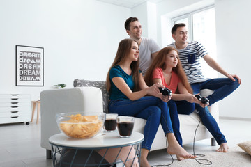 Young people playing video games at home © Pixel-Shot