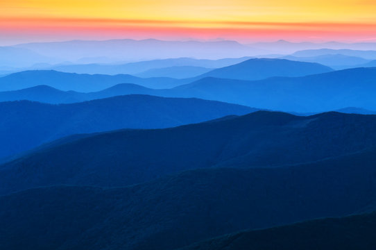 blue range of mountains on sunset