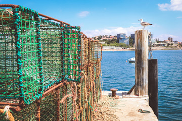 Rusty fishing traps, made of iron bars and green nylon nets, piled up on a dock  a pier in Cascais, Portugal 