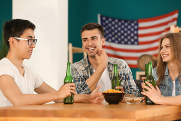 Group of cheerful friends drinking beer in bar