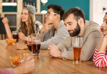 Group of friends drinking beer in bar