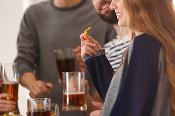 Young woman with friends drinking beer in bar
