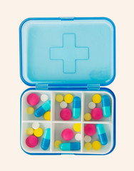 Set of pills in a pillbox on white background.