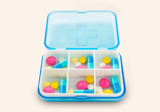 Set Of Pills In A Pillbox On White Background.