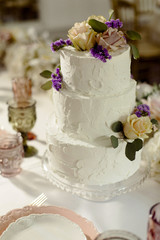 White wedding cake with flowers and blueberries