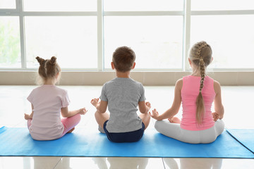 Little children practicing yoga indoors