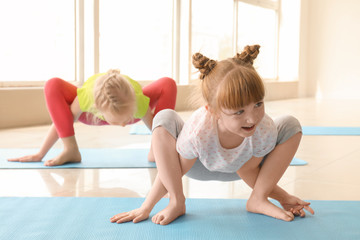 Little children practicing yoga indoors