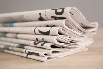 Pile of various newspapers on table