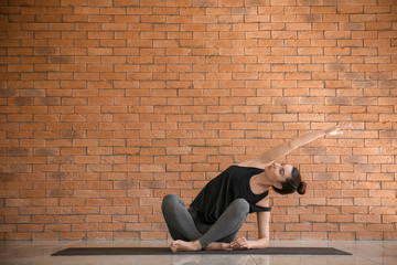 Fototapeta na wymiar Young woman practicing yoga indoors