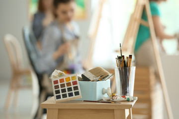 Table with paints and tools in artist's workshop