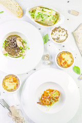 Different salads on wooden table, top view. Vegetable salad, Salad with smoked salmon, Baked meat with vegetables. Food background, Top view