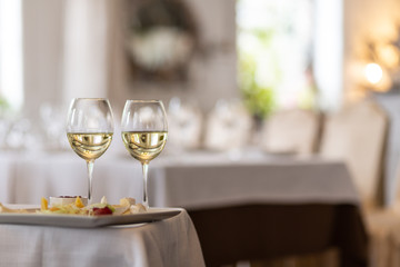 Photo of bottle with pouring champagne in wine glasses on gray background