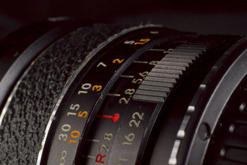 DSLR vintage wide lens close up with focus ring measures. Precise photography concept.