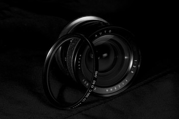 Vintage wide DSLR lens aperture close up with UV filter.