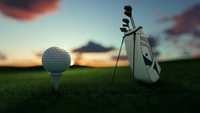 Golf clubs and golf ball on tee against beautiful timelapse sunrise, tilt