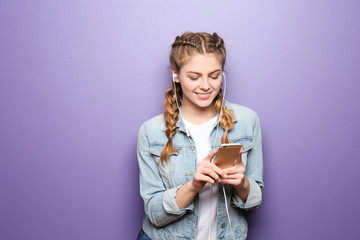 Beautiful young woman listening to music on color background