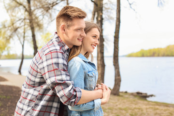 Happy young couple near river on spring day