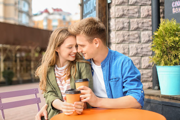 Happy young couple in cafe outdoors