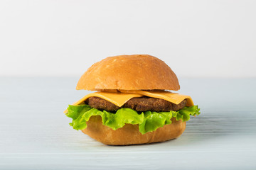 Craft beef burger on wooden table isolated on white background