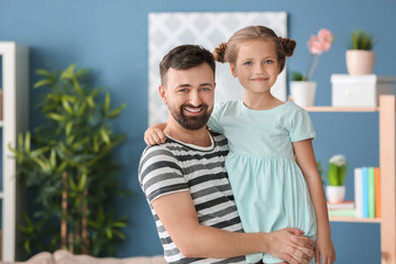 Fototapeta premium Portrait of smiling father and daughter at home