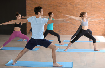Fototapeta na wymiar Group of people practicing yoga in gym