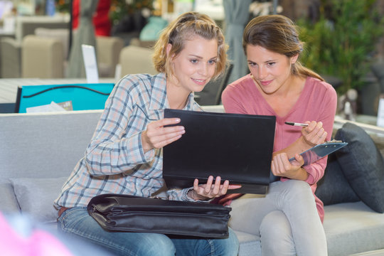 young women using laptop on sofa
