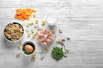 Composition with pet food and different products on wooden background