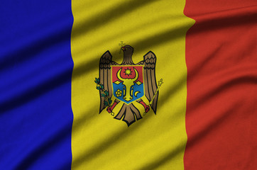 Moldova flag  is depicted on a sports cloth fabric with many folds. Sport team banner