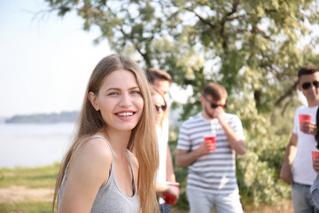 Obraz premium Young woman with friends at party on sunny day outdoors