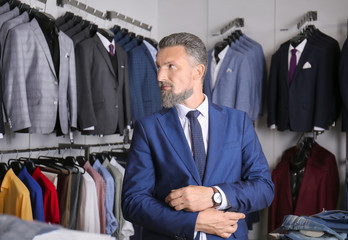 Handsome mature man in stylish suit at menswear store