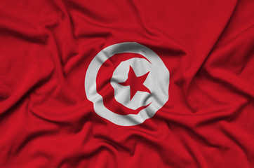 Tunisia flag  is depicted on a sports cloth fabric with many folds. Sport team banner