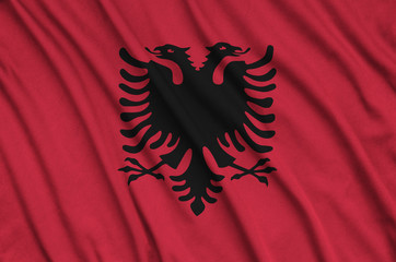  Albania flag  is depicted on a sports cloth fabric with many folds. Sport team banner