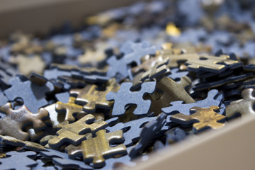 Close-up of a lot of pieces of a bluish jigsaw puzzle inside its box.