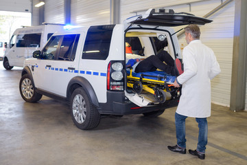 Paramedic unloading patient from ambulance
