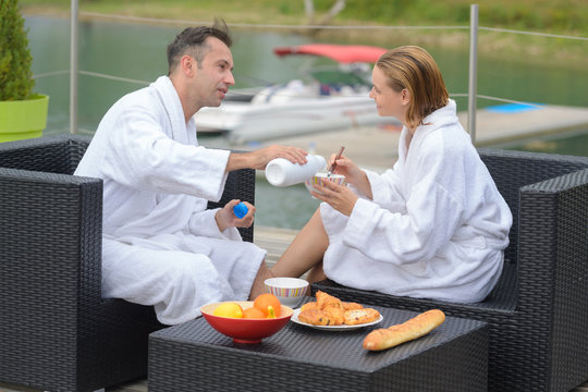 Couple Eating Breakfast On A Table At Beautiful Lake