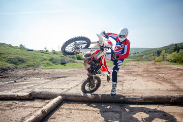 Hard enduro motorcycle rider practicing tricks on an obstacle course. Extreme outdoor motor sports.