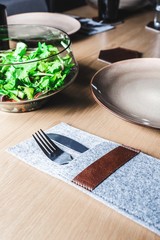 Cutlery socket and a salad on a wooden table