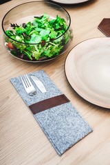 Cutlery socket and a salad on a wooden table