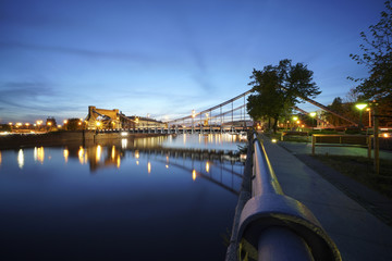 Illuminated Bridge over reflecting River