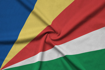 Seychelles flag  is depicted on a sports cloth fabric with many folds. Sport team banner