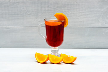 Glass with mulled wine near juicy orange fruit. Hot red mulled wine isolated on white background...