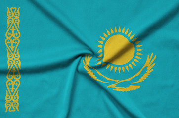Kazakhstan flag  is depicted on a sports cloth fabric with many folds. Sport team banner